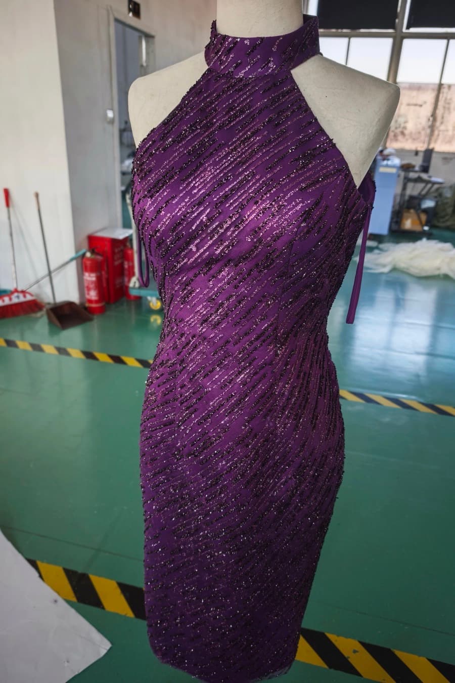 The same dress after manufacture, on a dress form on the workshop floor
